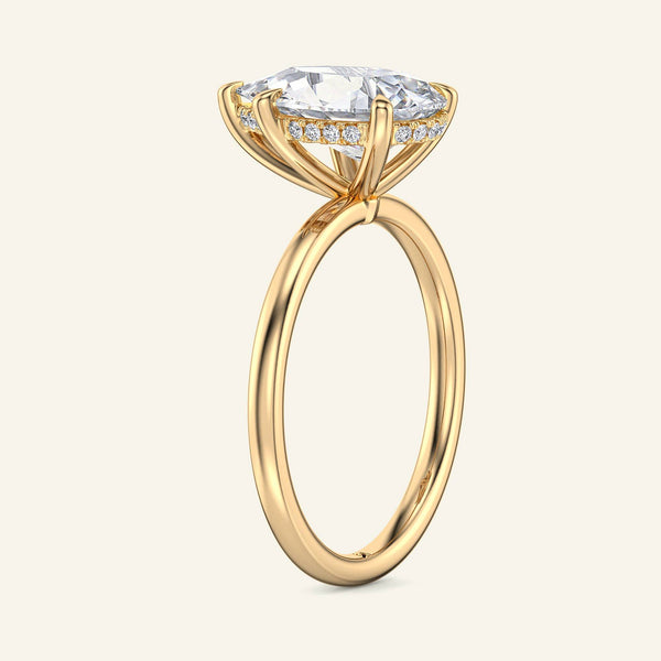 Side view of yellow gold hidden halo solitaire ring with pear shaped lab grown diamond. Unique sparkle with delicate band.