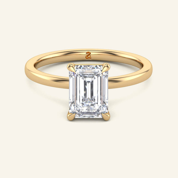 June Emerald Classic Solitaire Lab Grown Diamond Ring in yellow gold with a 2 carat emerald-cut diamond, featuring a sleek, timeless band.