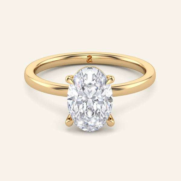 June Oval Classic Solitaire Diamond Ring in yellow gold with a 2 carat lab grown oval diamond, featuring a secure four-prong setting and polished band.