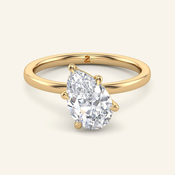 June Tilted Pear Classic Solitaire Diamond Ring in yellow gold with a 2 carat lab grown pear-shaped diamond set at an elegant angle.