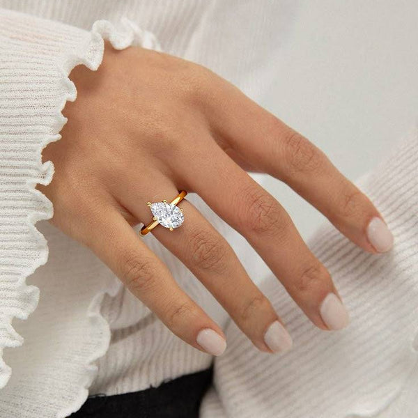 2 carat June Tilted Pear Classic Solitaire Diamond Ring worn on hand, showcasing the angled pear cut diamond and sleek gold band.