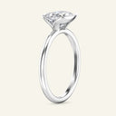 Profile view of the Mira Oval Half-Bezel Solitaire Diamond Ring in white gold, showing the open-ended bezel that allows light to pass through the diamond.