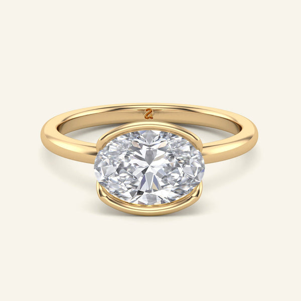 Mira Oval Half-Bezel Solitaire Diamond Ring in yellow gold with a 2 carat east-west set lab-grown oval diamond, showcasing a sleek modern bezel.