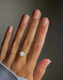 2 carat Mira Oval Half-Bezel Solitaire Diamond Ring worn on hand, featuring an east-west oval diamond in yellow gold for a minimalist engagement look.
