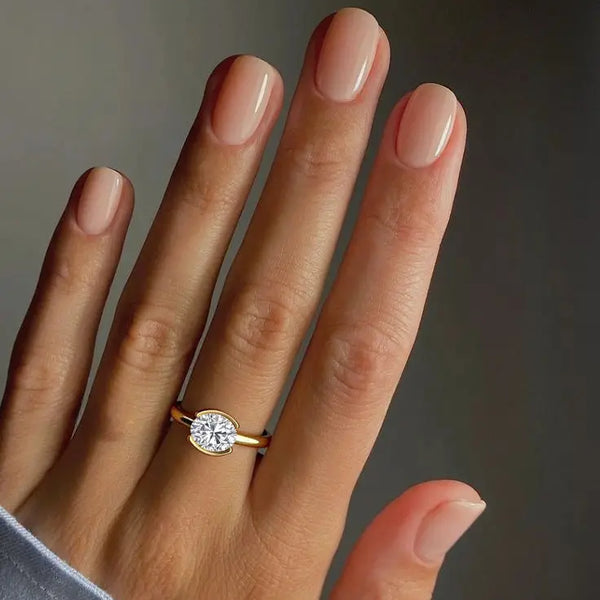 2 carat Mira Oval Half-Bezel Solitaire Diamond Ring worn on hand, featuring an east-west oval diamond in yellow gold for a minimalist engagement look.