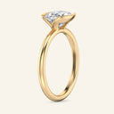 Side view of the Mira Oval Half-Bezel Solitaire Diamond Ring in yellow gold, highlighting the open bezel design that enhances diamond brilliance.