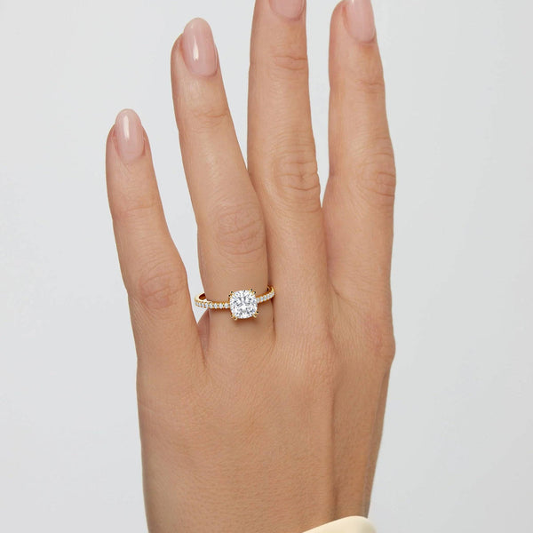 2 carat Cora Cushion Cathedral Pavé Solitaire Diamond Ring on hand, showcasing elegant yellow gold setting and sparkling cushion-cut center stone.
