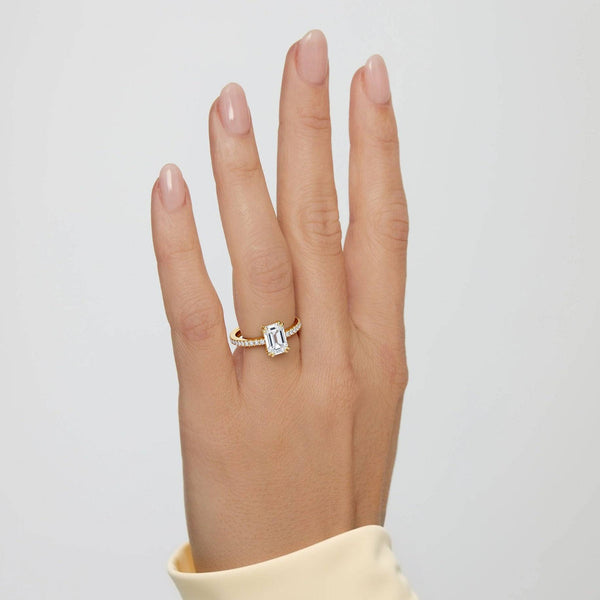 2 carat Cora Emerald Cathedral Pavé Solitaire Diamond Ring worn on hand, showcasing the elegant yellow gold band and emerald-cut center stone.