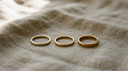 Three solid gold band rings in different gold purities showing 9k, 14k and 18k colour differences