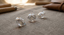 Loose colourless lab-grown diamonds, the April birthstone, on warm greige linen