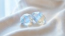 Two luminous faceted gemstones on ivory silk, illustrating a two carat lab-grown diamond