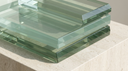 Architectural green-tinted step-cut glass facets, illustrating an emerald cut lab-grown diamond