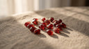 Loose deep-red garnet gemstones, the January birthstone, on warm greige linen
