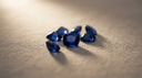 Loose deep blue sapphire gemstones, the September birthstone, on warm greige linen