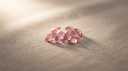 Loose rose-pink tourmaline gemstones, the October birthstone, on warm greige linen