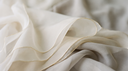 Soft folds of pale ivory and champagne silk with a thread of gold light