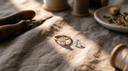 Oval lab-grown diamond engagement ring in solid gold beside a loose oval diamond on warm greige linen