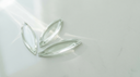 Marquise-cut lab-grown diamond engagement ring concept — three pointed-oval navette crystals on pale stone in soft daylight