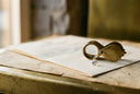 A jeweler's loupe and a loose lab-grown diamond resting on a grading report, in warm editorial light