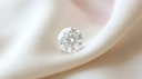 Round brilliant-cut lab-grown diamond on ivory silk, illustrating a round engagement ring stone