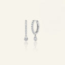 Lab grown diamond drop huggie earrings in 14K white gold featuring sparkling round diamonds. Stylish and sustainable accessory choice.