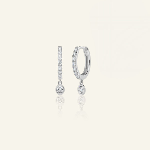 Lab grown diamond drop huggie earrings in 14K white gold featuring sparkling round diamonds. Stylish and sustainable accessory choice.